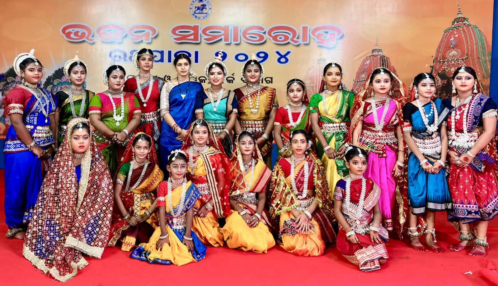 Dancers of the academy assembled with a memento before a festival banner